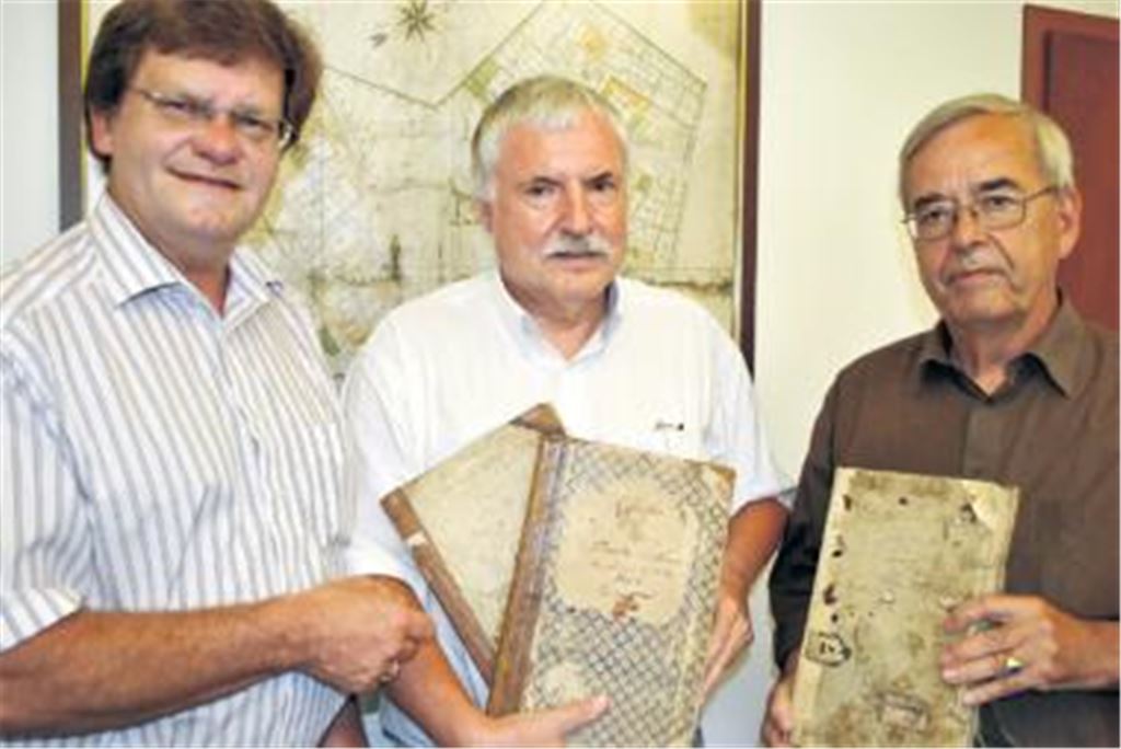 Wieder daheim: Die Professoren Claus Hobe Schröder (v.re.) und Karl Werner Knopf übergeben Bürgermeister Karlheinz Oehler drei alte Kirchenbücher von Serres und Pinache.
Foto: Stahlfeld