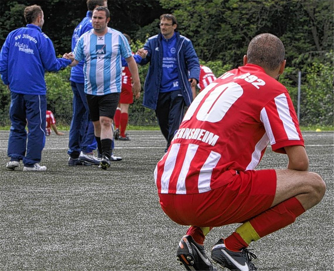 Wiernsheims Spielmacher Semih Ergün kauert enttäuscht am Boden. Im Hintergrund beglückwünschen sich die Illinger zum Sieg. Foto: Eigner