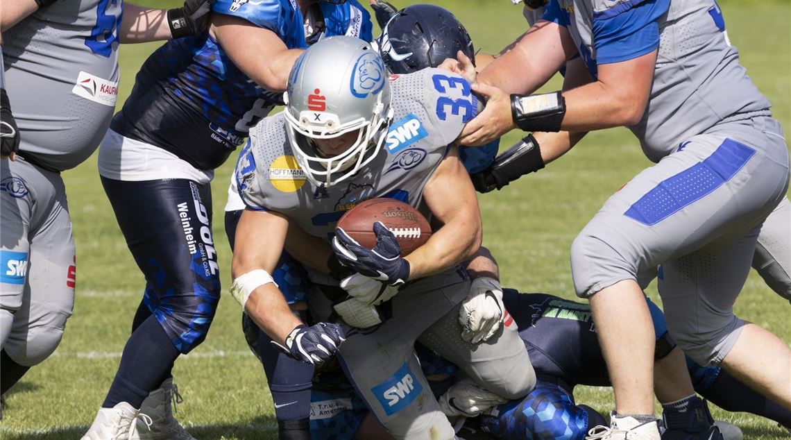 Wilddogs-Spieler Theo Michel verteidigt auf heimischem Rasen den Ball vor den Weinheim Longhorns. Foto: Julian Hanser