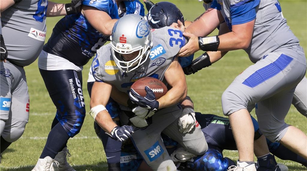 Wilddogs-Spieler Theo Michel verteidigt auf heimischem Rasen den Ball vor den Weinheim Longhorns. Foto: Julian Hanser