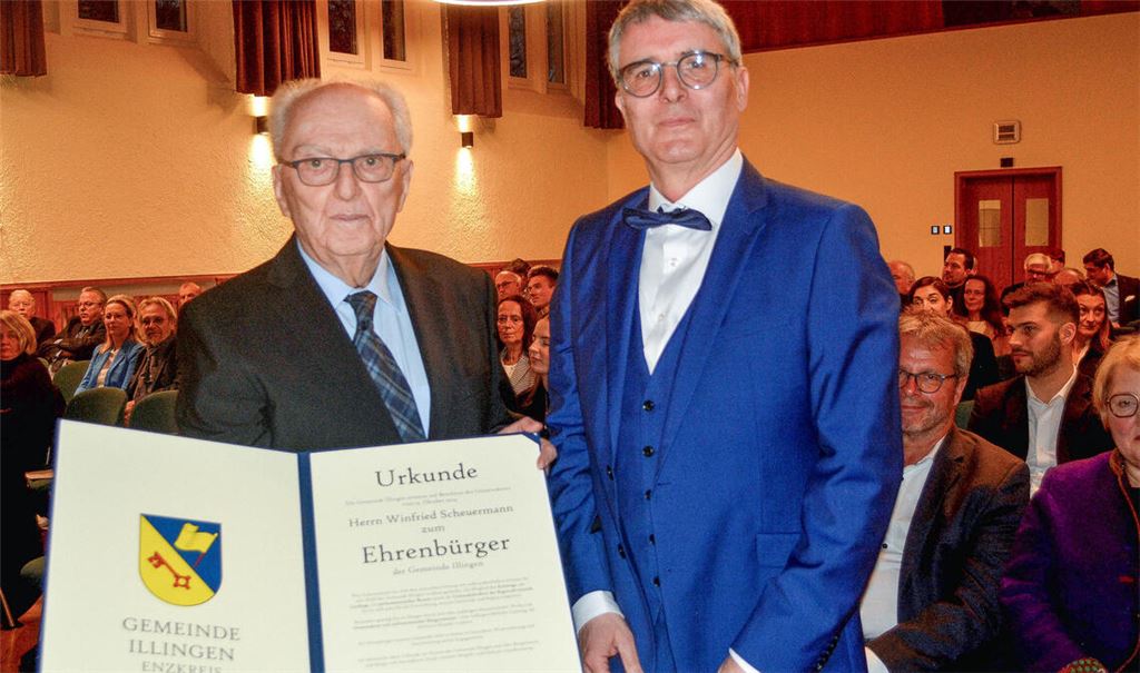 Winfried Scheuermann (li.) bekommt von Bürgermeister Armin Pioch die Urkunde überreicht. Zur Verleihung gratulieren zahlreiche prominente Weggefährten.