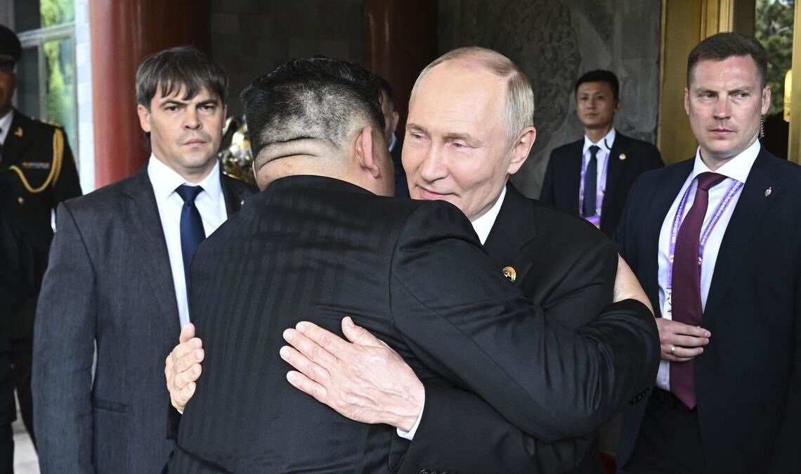 Wladimir Putin (M,r-l) und Kim Jong-un umarmen sich am Rande der Militärparade in Peking.