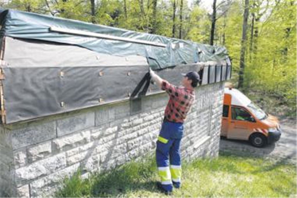 Wo einst eine Kupferverwahrung war, schaut jetzt der nackte Unterbau hervor. Bis Ersatz für die rund 200 gestohlenen Kupferplatten beschafft ist, will die Gemeinde den von Dieben bloß gelegten Rand ihres Wasserhochbehälters provisorisch mit Planen schützen. 
Foto: Tilo Keller