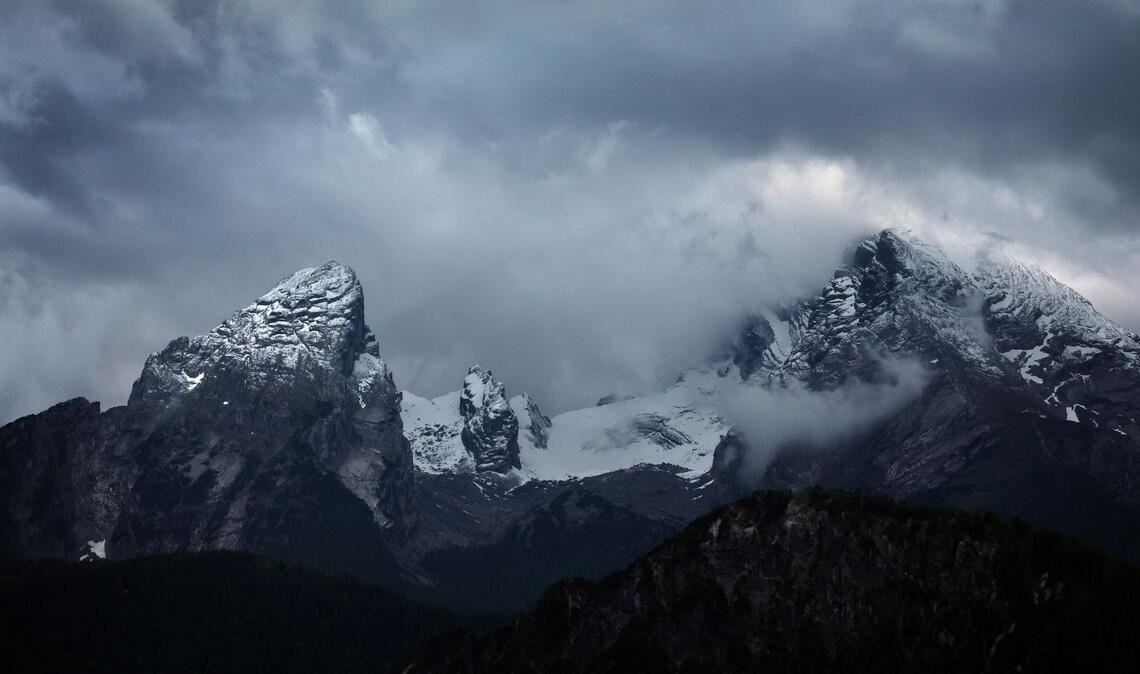 Wolkenverhangen ist der schneebedeckte Watzmann.