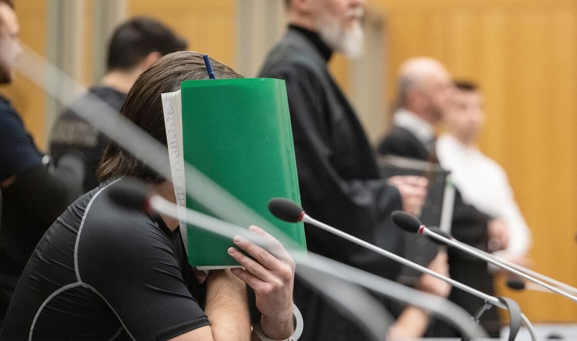 Yevhen B. hält sich beim Prozessauftakt vor dem Stuttgarter Oberlandesgericht eine Akten vor sein Gesicht: leicht und billig zu ersetzen.