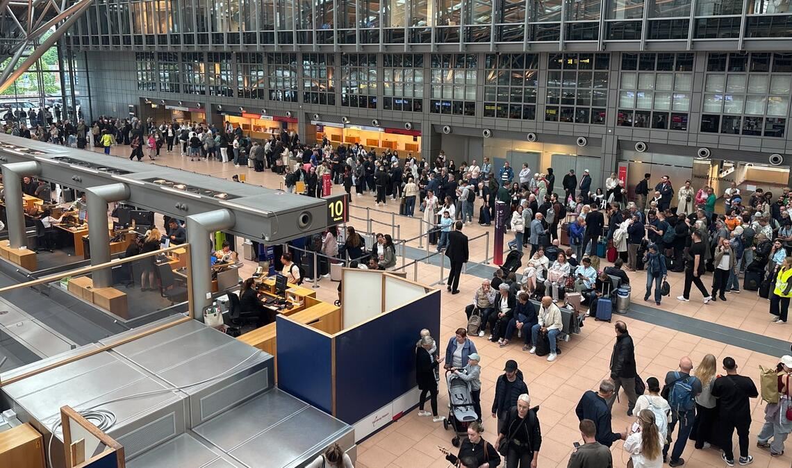Zahlreiche Menschen stehen im Terminal des Hamburger Flughafens.