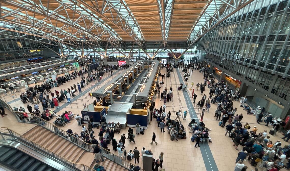 Zahlreiche Menschen stehen im Terminal des Hamburger Flughafens.