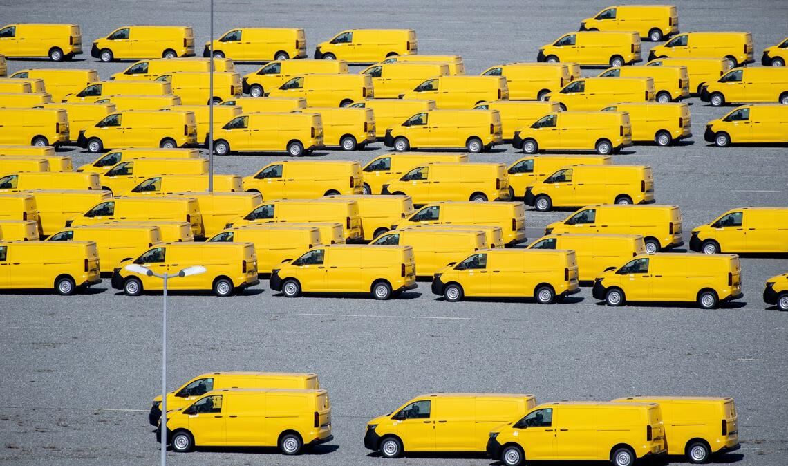 Zahlreiche gelbe Neufahrzeuge vom Typ Volkswagen T7 für die Deutsche Post stehen auf einem Gelände am JadeWeserPort in Wilhelmshaven und werden dort vor Auslieferung zwischengelagert.