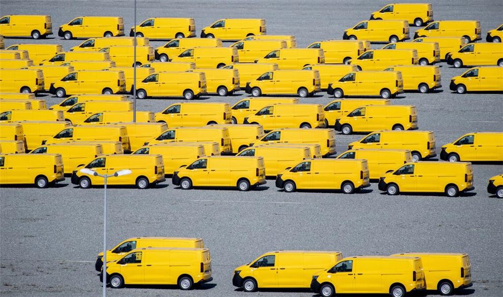Zahlreiche gelbe Neufahrzeuge vom Typ Volkswagen T7 für die Deutsche Post stehen auf einem Gelände am JadeWeserPort in Wilhelmshaven und werden dort vor Auslieferung zwischengelagert.