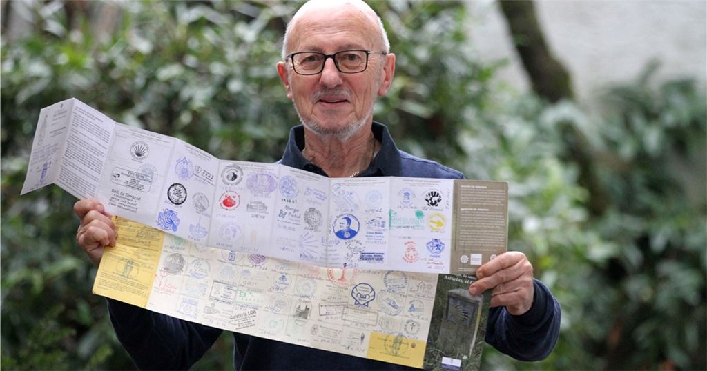 Zeugen einer Reise nach Santiago de Compostela: Wolfgang Frommer zeigt seine Pilgerbücher mit Stempeln. Foto: Goertz