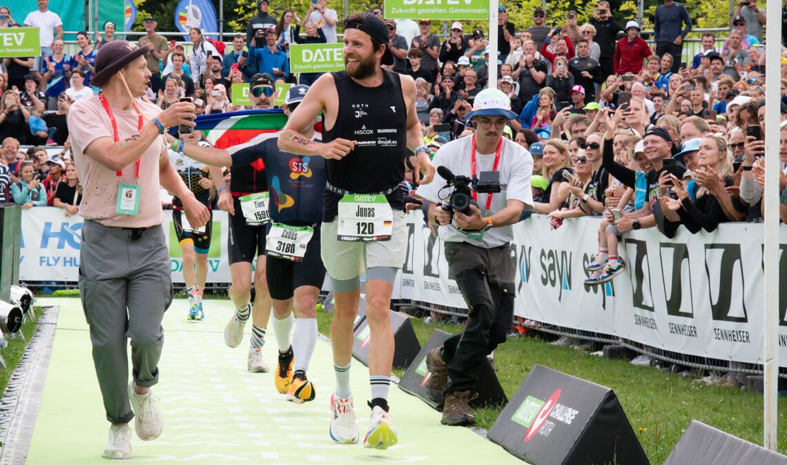 Zieleinlauf mit Erinnerungsfoto: Beim Challenge Roth wird Jonas Deichmann von Tausenden begeisterten Fans empfangen. Fotos: Johannes Jank, Marc Bernreuther