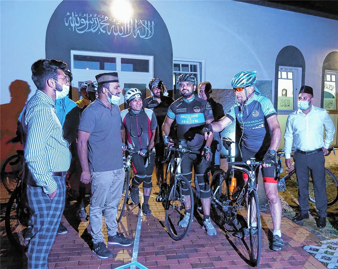 Zu später Stunde begrüßt Wahab Ghumon, Sprecher der Pforzheimer Ahmadiyya-Gemeinde (2. v.li.), den Bundesvorsitzenden Abdullah Uwe Wagishauser (2. v.re.) und seine Mitstreiter, die derzeit eine Tour mit dem Fahrrad durch Deutschland unternehmen. Foto: Stefan Friedrich