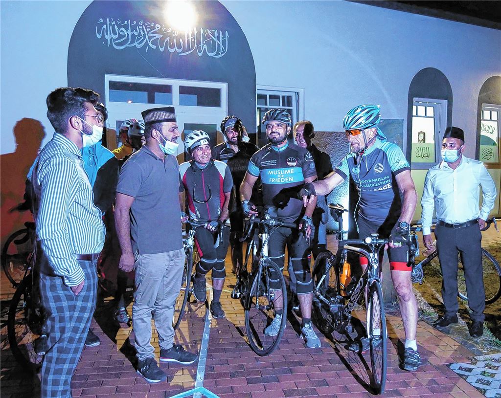 Zu später Stunde begrüßt Wahab Ghumon, Sprecher der Pforzheimer Ahmadiyya-Gemeinde (2. v.li.), den Bundesvorsitzenden Abdullah Uwe Wagishauser (2. v.re.) und seine Mitstreiter, die derzeit eine Tour mit dem Fahrrad durch Deutschland unternehmen. Foto: Stefan Friedrich
