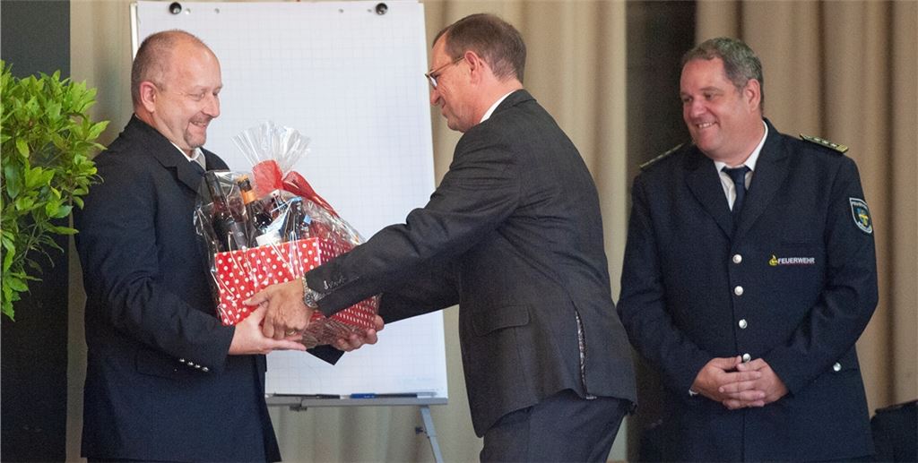 Zuletzt hatten Marko Reichenbach (links) und Matthias Donath (rechts) die Feuerwehr stellvertretend geleitet. Mühlackers Oberbürgermeister Frank Schneider überreichte ihnen als Dank einen Geschenkkorb. Foto: Fotomoment