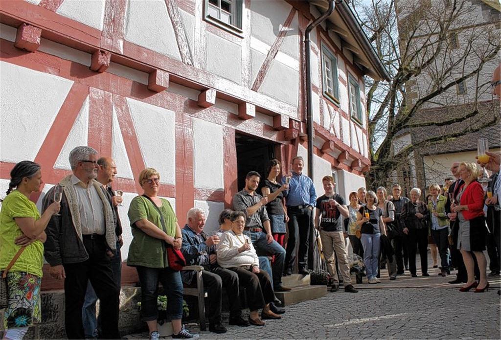 Zum Wohl: Monika und Frank Becker (im Eingang) stoßen mit ihren Gästen auf das sanierte Fachwerkhaus an.