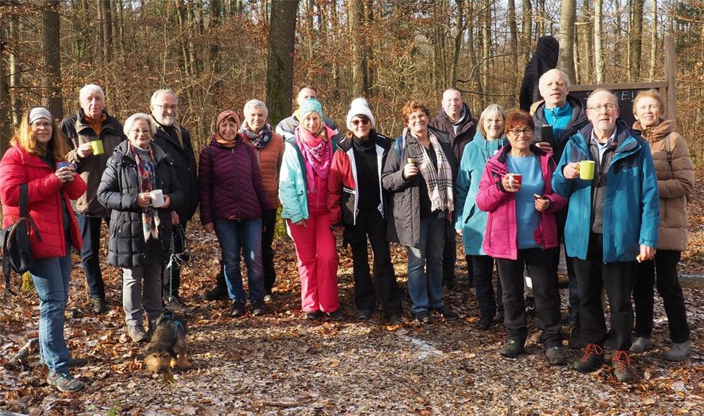 Zusammen mit Wanderführer Adi Pfau (Zweiter v. re.) genießt die Wandergruppe an der Nieferner Waldschule eine wohlverdiente Pause mit Glühwein und Butterbrezeln.