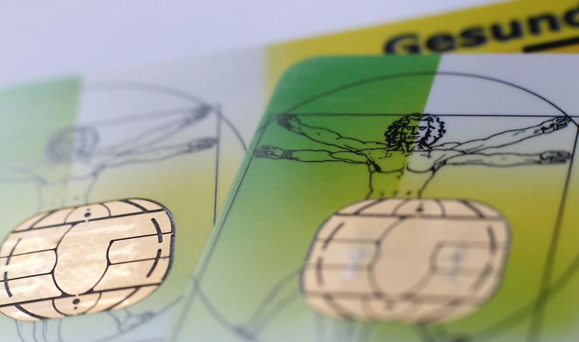 Zwei elektronische Versichertenkarten der Allgemeinen Ortskrankenkassen (AOK) liegen auf einem Tisch.