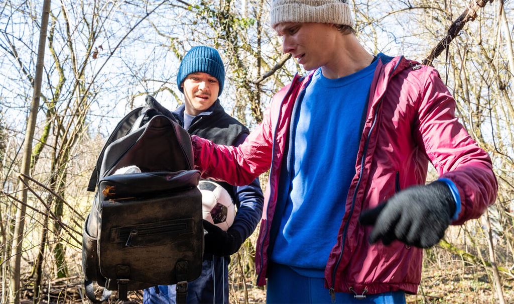 Zwei junge Männer entdecken beim Fußballspielen eine Tasche. Der Inhalt offenbart ein Verbrechen, das die Polizei auf den Plan ruft.