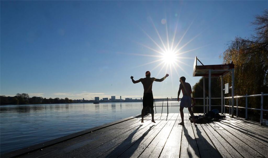 Zwei junge Männer haben Spaß beim Eisbaden in Hamburg an der Alster.